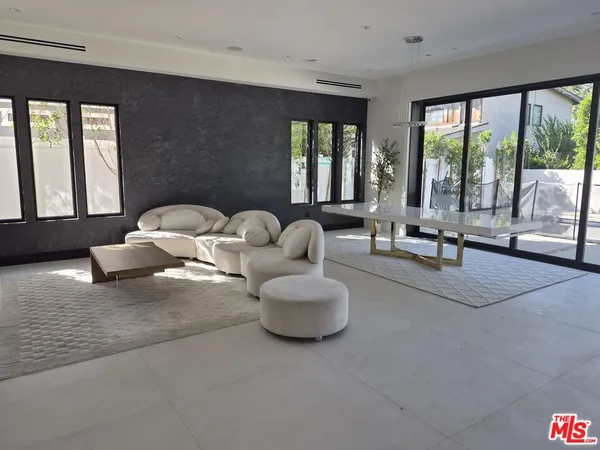 a living room with furniture and large windows