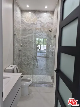 a bathroom with a granite countertop bathtub shower sink and toilet