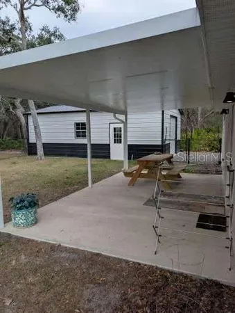 a view of a patio with table and chairs next to a yard