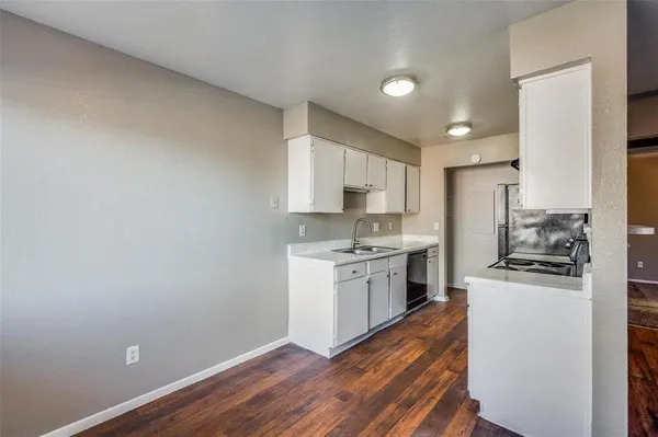 a kitchen with granite countertop a stove top oven sink and cabinets