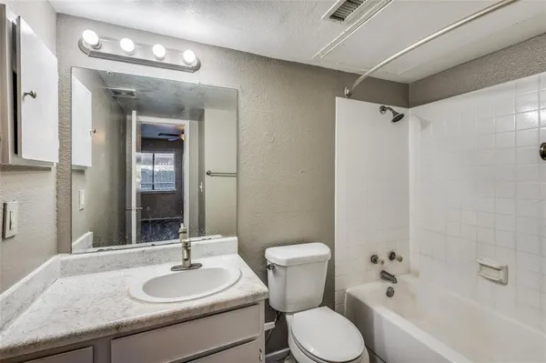 a bathroom with a granite countertop sink toilet a mirror and shower