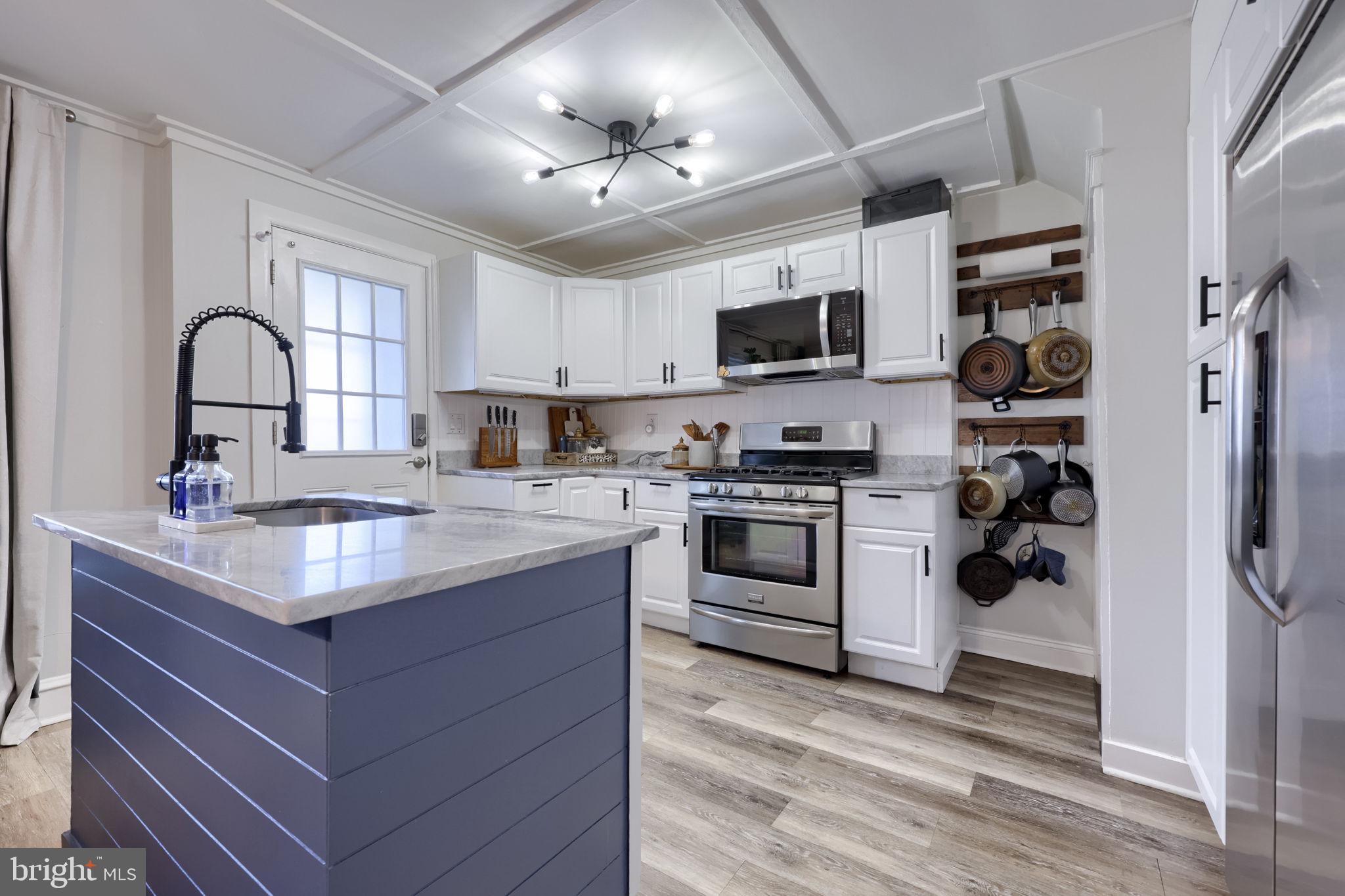 827 3rd Street Lancaster, PA 17603 - Photo 18 of 37 a kitchen with stainless steel appliances granite countertop a sink dishwasher stove and refrigerator with wooden floor