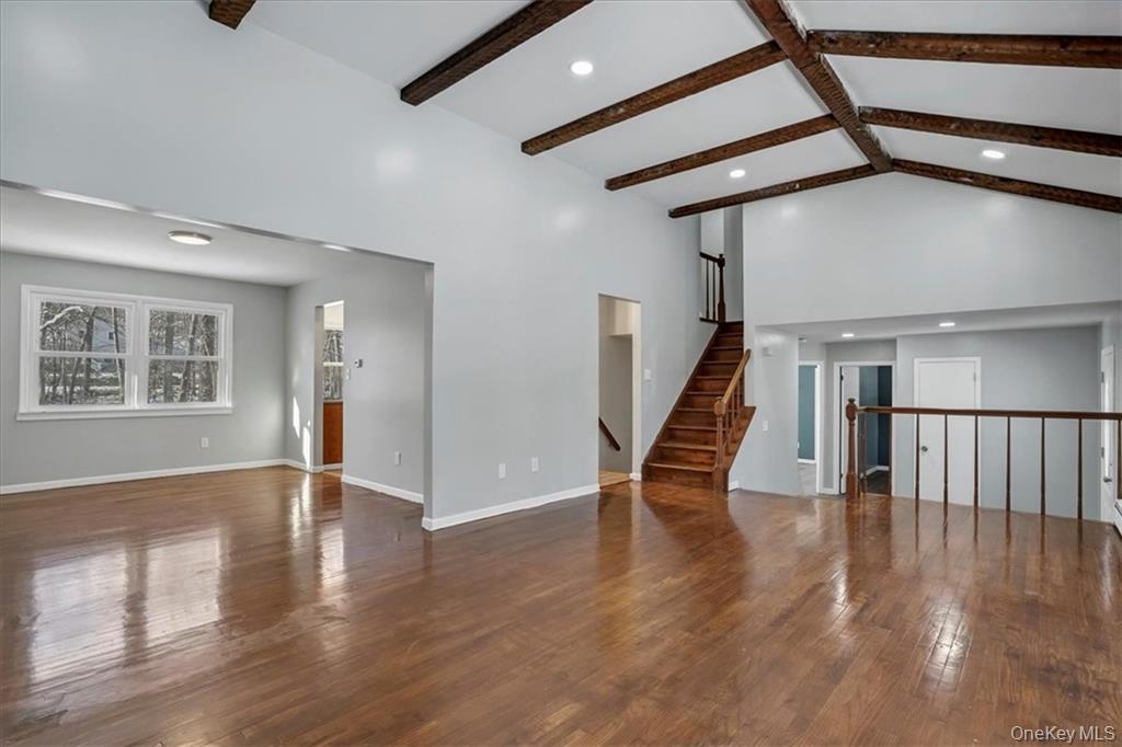 36 Ironworks Road Monroe, NY 10950 - Photo 11 of 37 Unfurnished living room featuring dark wood-style floors, beamed ceiling, high vaulted ceiling, recessed lighting, and stairs