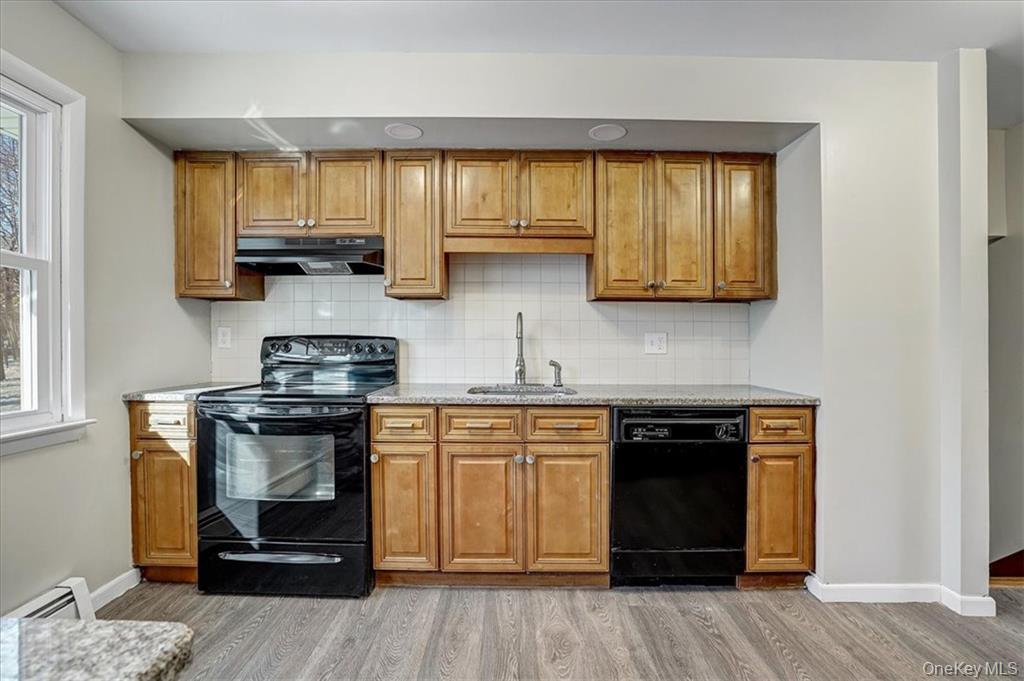 36 Ironworks Road Monroe, NY 10950 - Photo 15 of 37 Kitchen with black appliances, brown cabinetry, and decorative backsplash