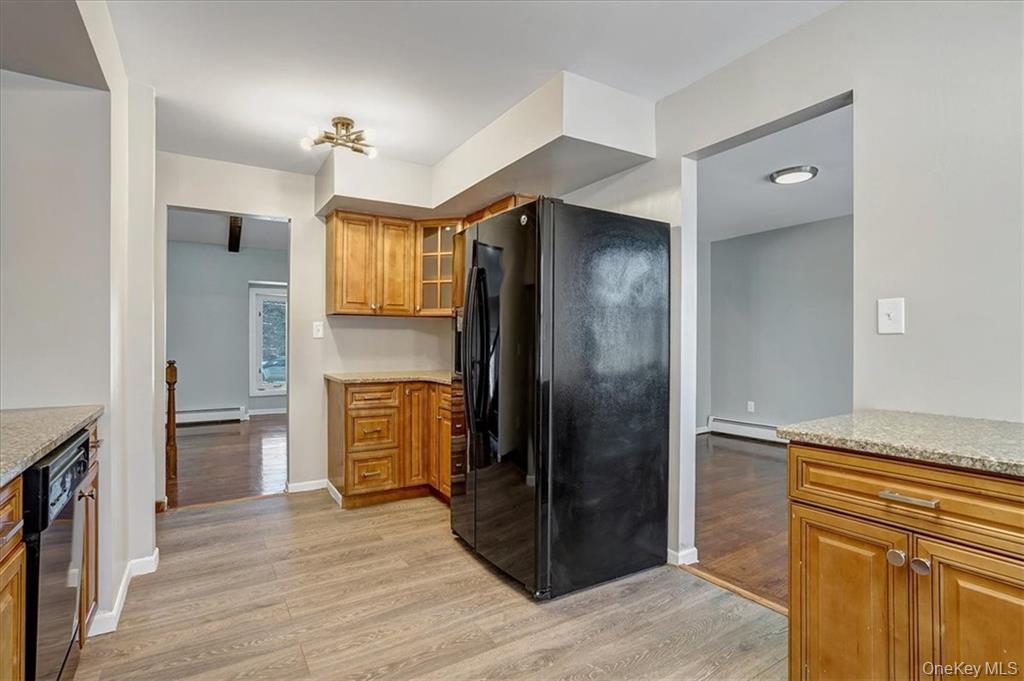36 Ironworks Road Monroe, NY 10950 - Photo 18 of 37 Kitchen featuring black appliances, brown cabinetry, light wood-type flooring, and light stone countertops