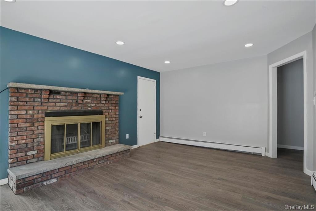 36 Ironworks Road Monroe, NY 10950 - Photo 20 of 37 Unfurnished living room with baseboard heating, wood finished floors, recessed lighting, and a fireplace