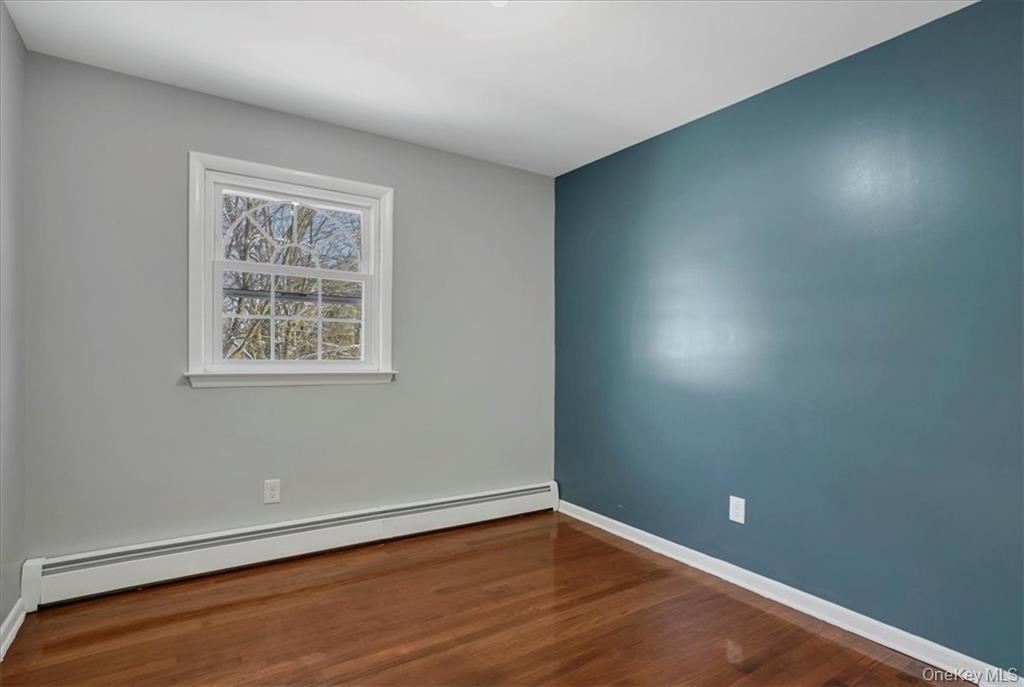 36 Ironworks Road Monroe, NY 10950 - Photo 25 of 37 Empty room featuring a baseboard radiator and dark wood-style floors