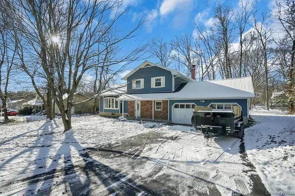 a front view of a house with a yard covered in snow