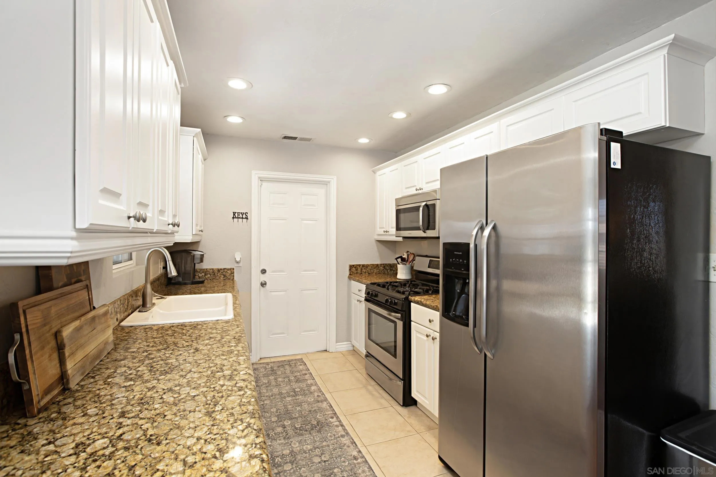 8823 Kelburn Avenue Spring Valley, CA 91977 - Photo 14 of 34 a kitchen with stainless steel appliances granite countertop a refrigerator a sink and a stove