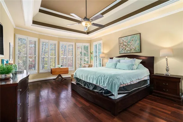 a bed sitting in a spacious bedroom next to a window