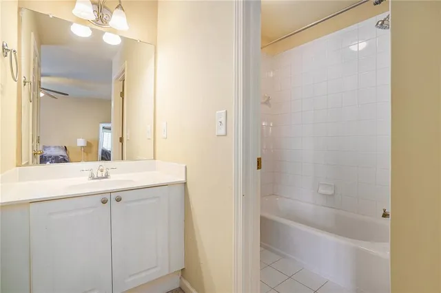 a bathroom with a granite countertop sink a mirror and a bathtub