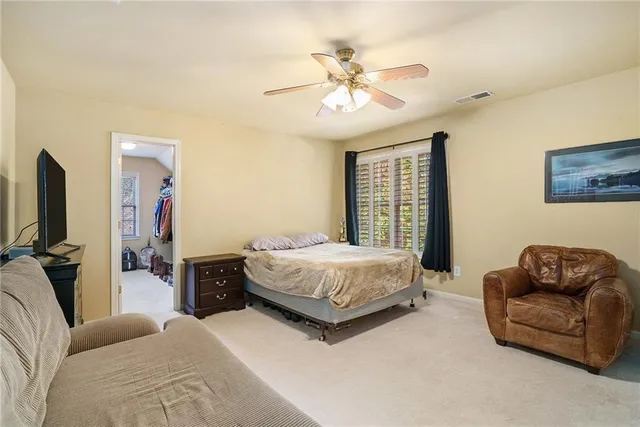 a bedroom with a bed couch and flat screen tv