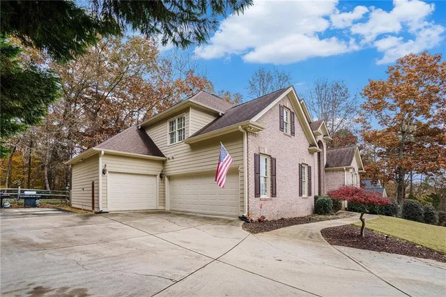 a view of a white house with a large tree