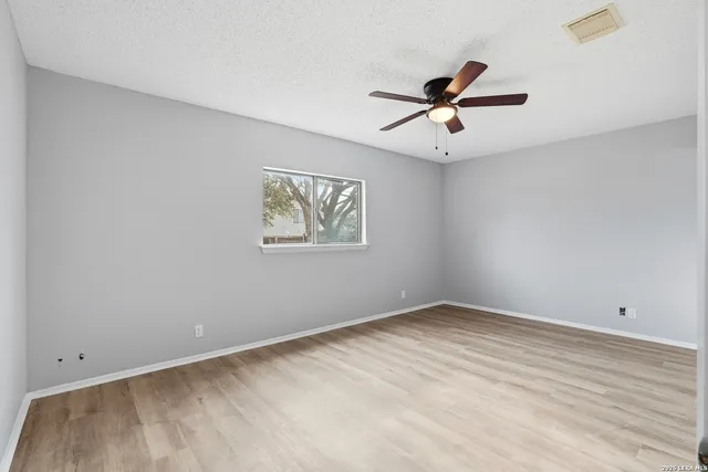 an empty room with a window and a ceiling fan