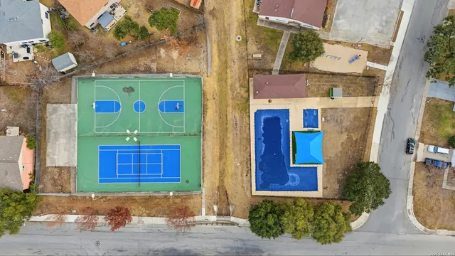 an aerial view of residential houses with outdoor space and parking