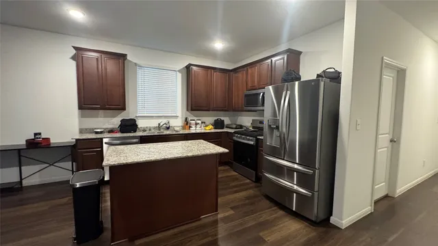a kitchen with granite countertop stainless steel appliances and wooden cabinets