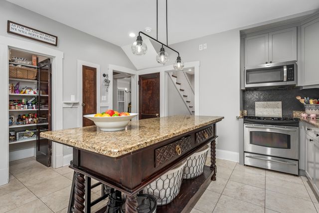 a kitchen with stainless steel appliances granite countertop a stove a sink and a refrigerator