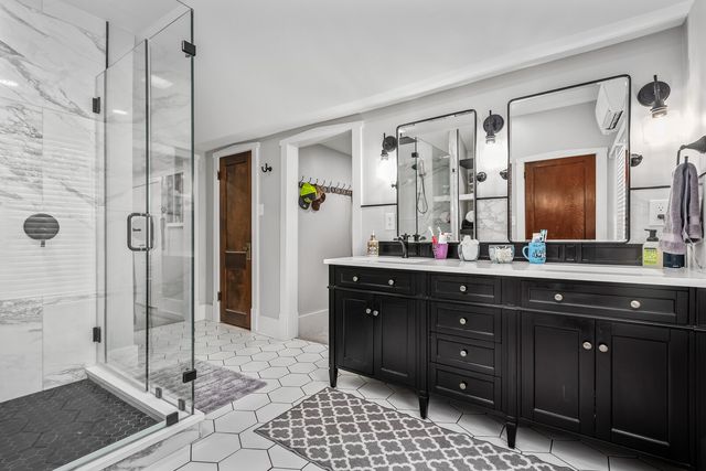 a bathroom with a granite countertop sink mirror and shower