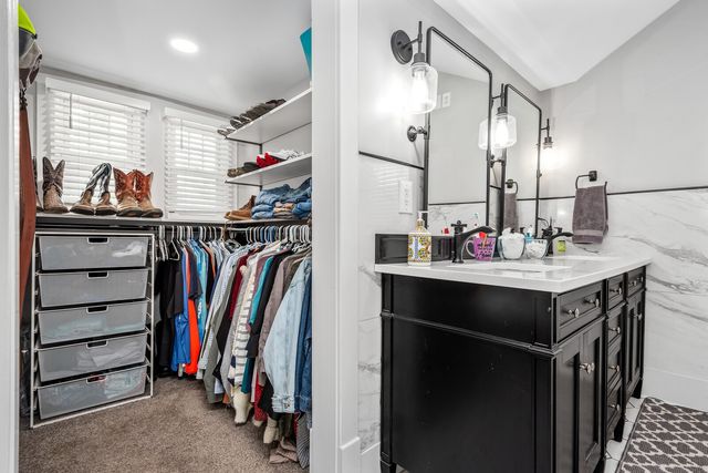 a view of walk in closet with clothes and shoes
