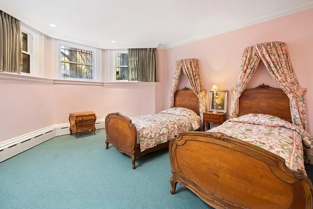 a bedroom with two beds and painting on the wall