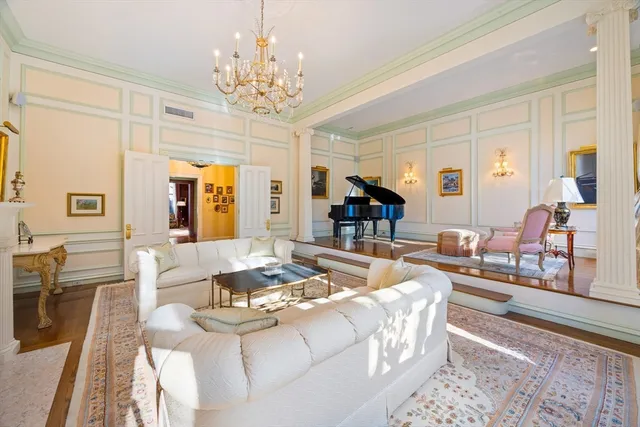 a living room with fireplace furniture and a chandelier