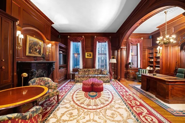 a living room with furniture a fireplace and large windows