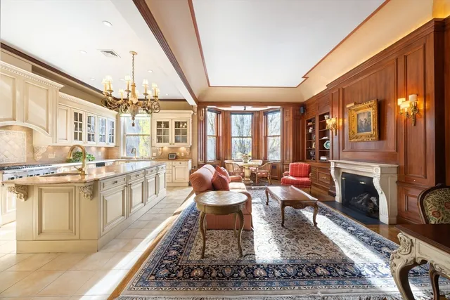 a living room with furniture a fireplace and a kitchen view