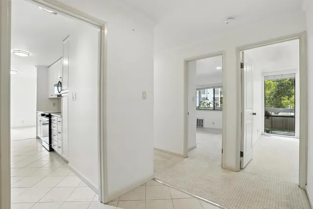 a view of a hallway with bathroom and glass door
