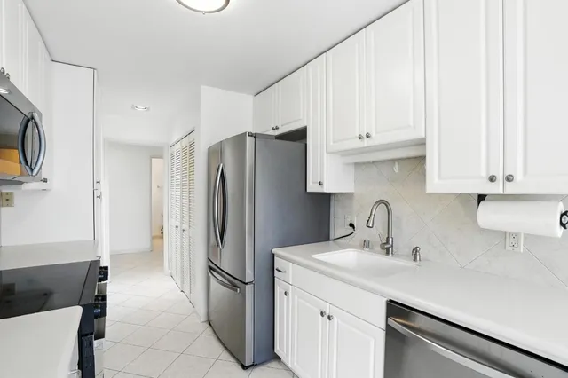 a kitchen with stainless steel appliances a refrigerator sink and cabinets