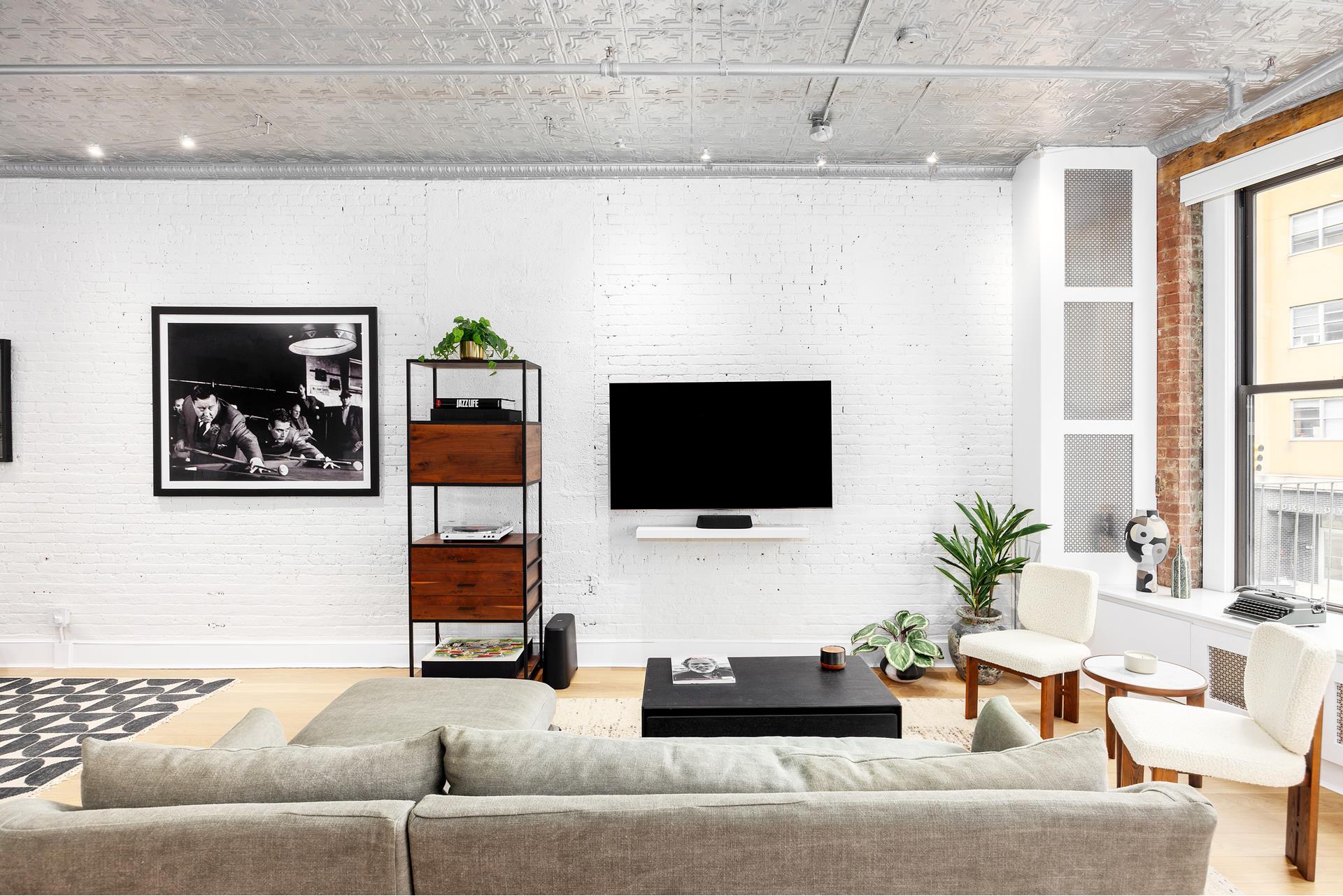 242 Lafayette Street, Unit 2N Manhattan, NY 10012 - Photo 3 of 13 a living room with furniture and a flat screen tv