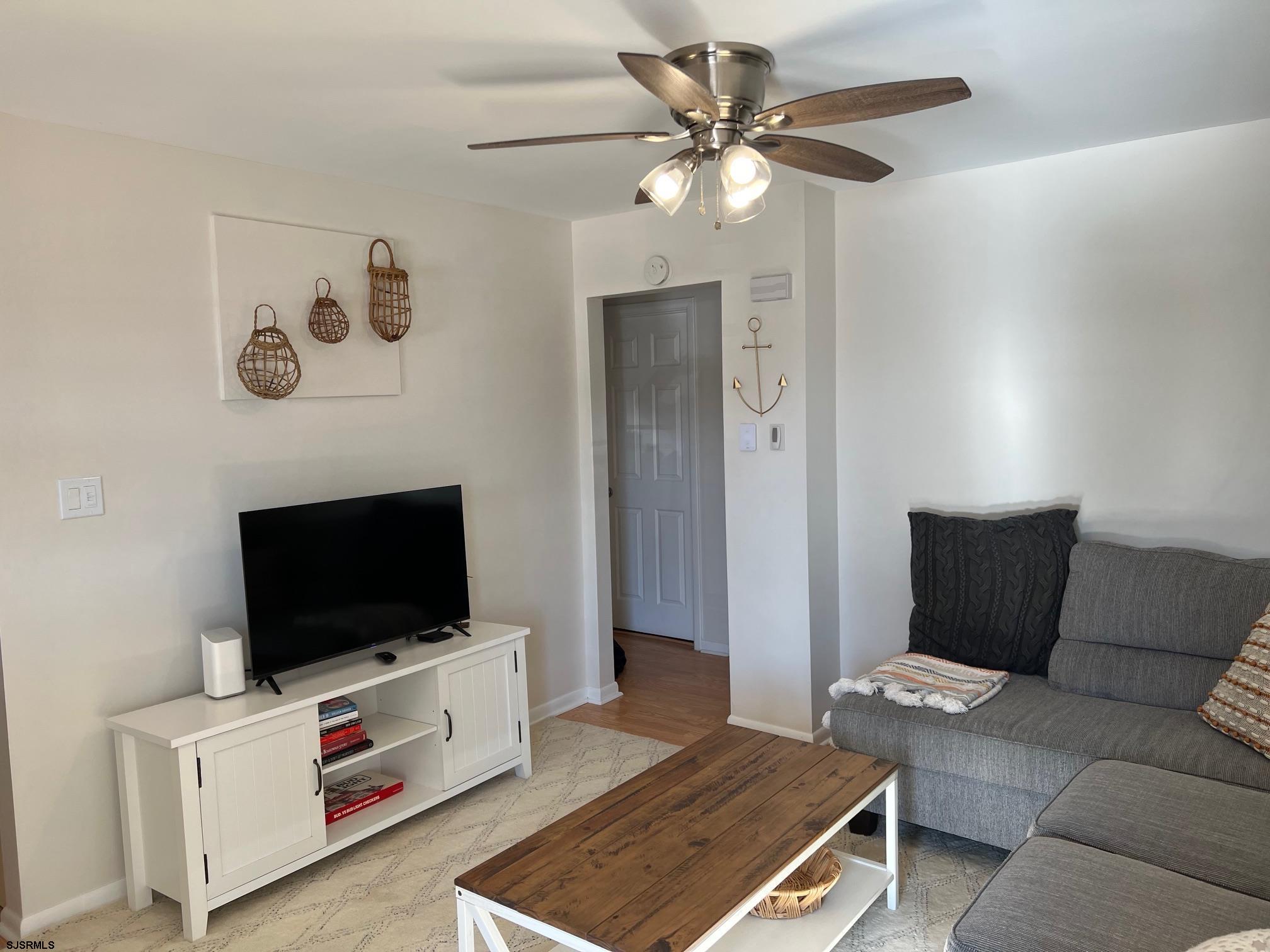 1013 West Brigantine Avenue, Unit 4 Brigantine, NJ 08203 - Photo 2 of 18 a living room with furniture and a flat screen tv