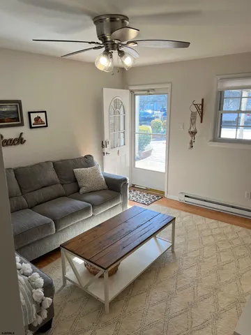 a living room with furniture a flat screen tv and a window