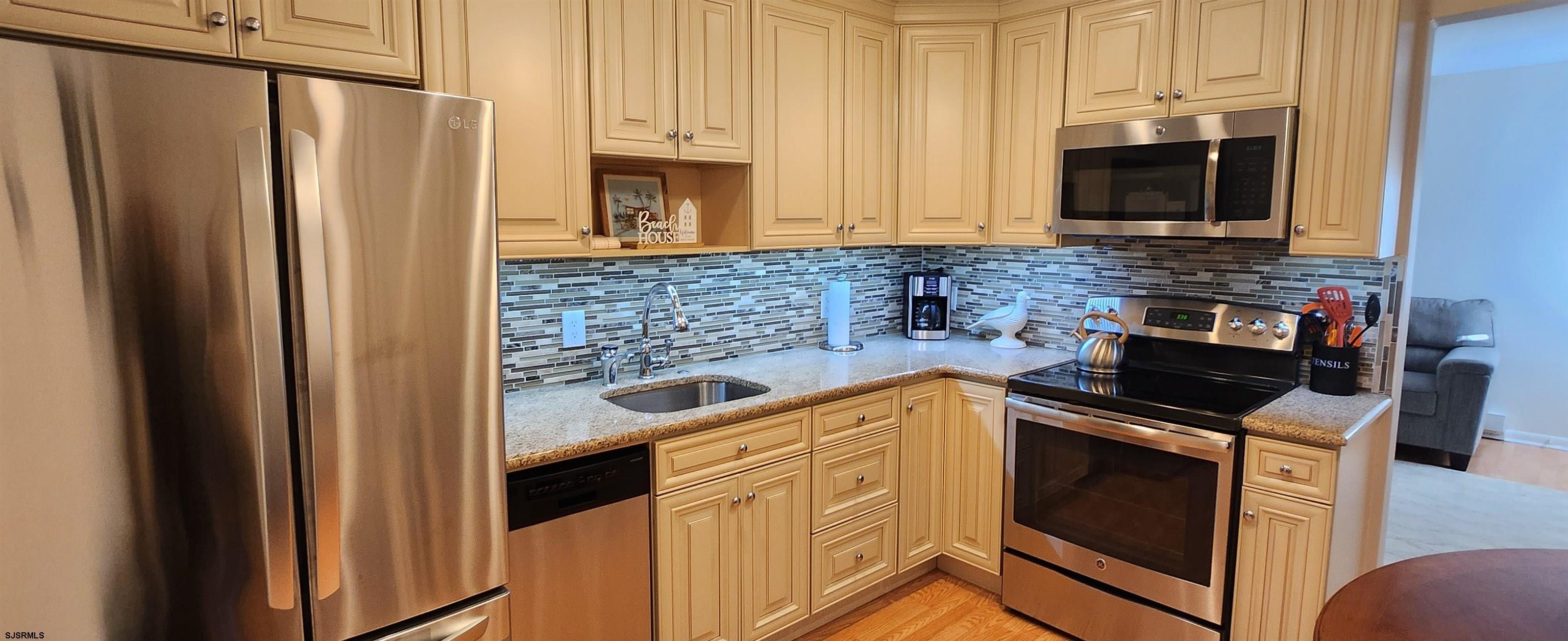 1013 West Brigantine Avenue, Unit 4 Brigantine, NJ 08203 - Photo 9 of 18 a kitchen with stainless steel appliances a stove microwave and refrigerator