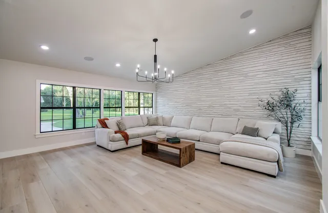 a living room with furniture and a chandelier