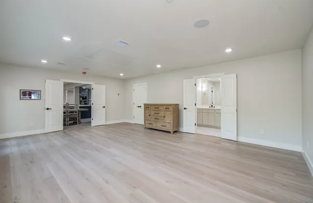 a view of empty room with wooden floor and windows