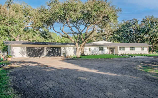 a front view of house with yard and trees around