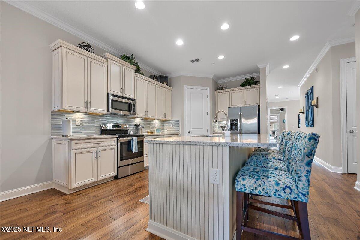 95220 Summerwoods Circle, Unit 1205 Fernandina Beach, FL 32034 - Photo 17 of 32 a kitchen with stainless steel appliances granite countertop a refrigerator a stove top oven a sink dishwasher and white cabinets with wooden floor