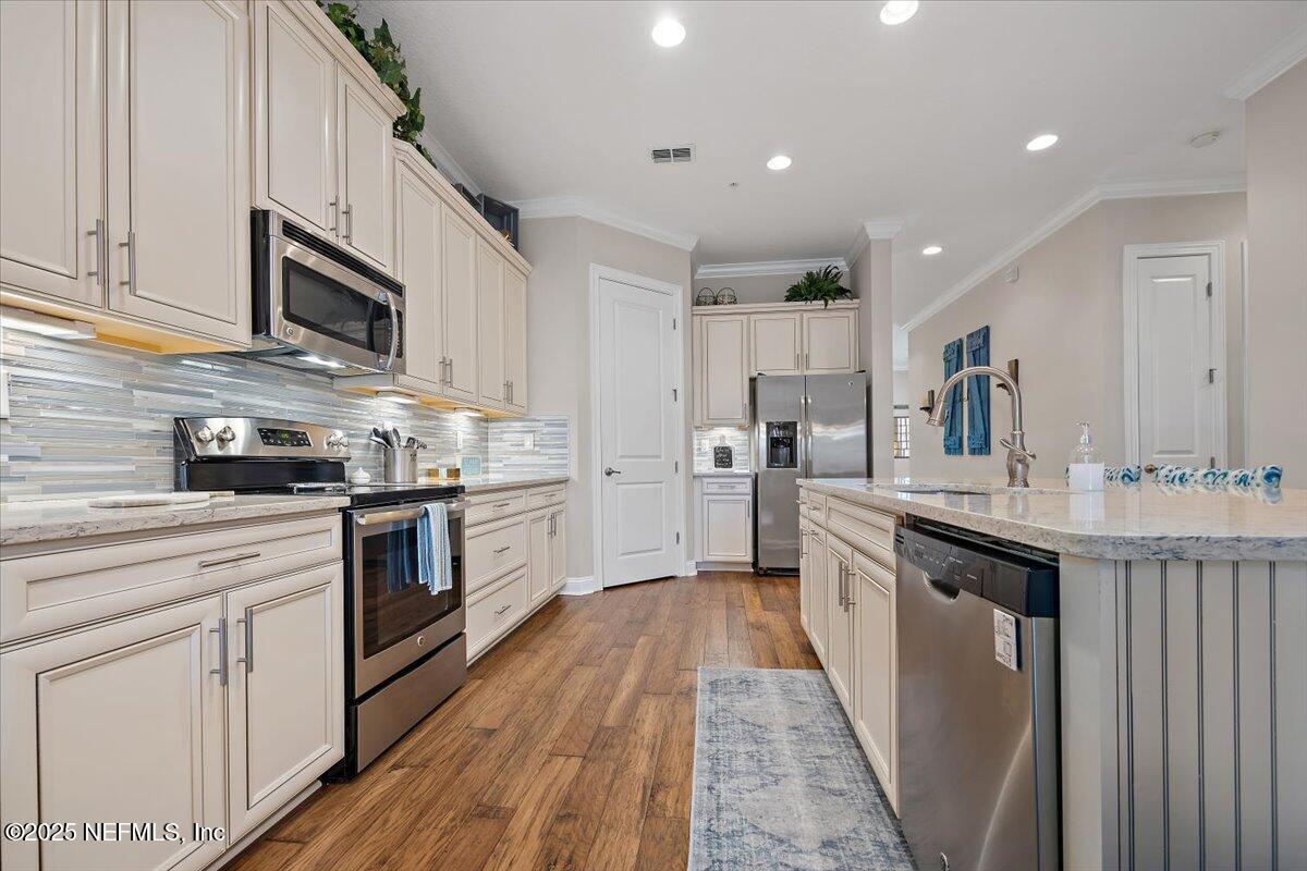 95220 Summerwoods Circle, Unit 1205 Fernandina Beach, FL 32034 - Photo 18 of 32 a kitchen with stainless steel appliances granite countertop a sink and cabinets