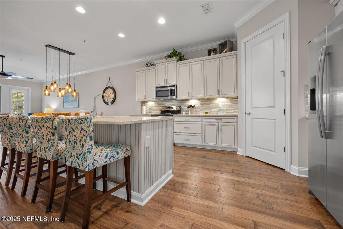 95220 Summerwoods Circle, Unit 1205 Fernandina Beach, FL 32034 - Photo 19 of 32 a kitchen with granite countertop a table chairs a sink dishwasher refrigerator and cabinets