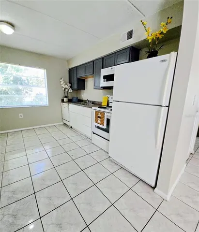 a kitchen with stainless steel appliances a refrigerator sink and microwave
