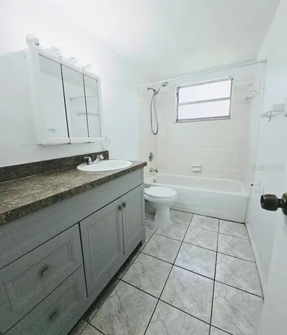 a bathroom with a granite countertop sink a toilet and a mirror