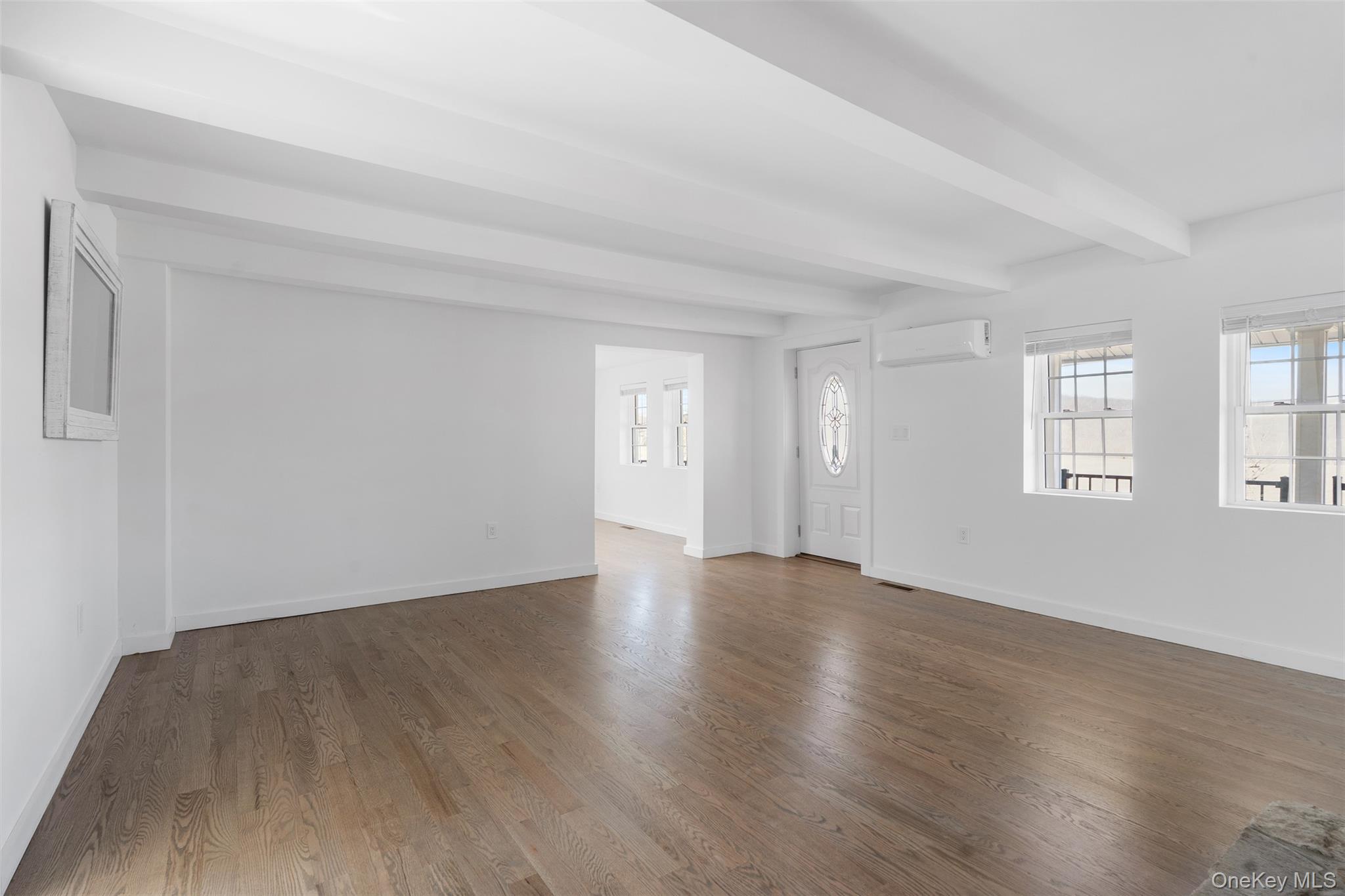 70 Barmore Road LaGrangeville, NY 12540 - Photo 12 of 47 Unfurnished living room with a wall mounted AC, beamed ceiling, and dark wood finished floors
