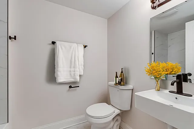 a bathroom with a sink a toilet and mirror