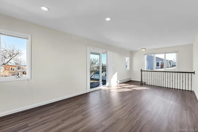 an empty room with a window and a ceiling fan