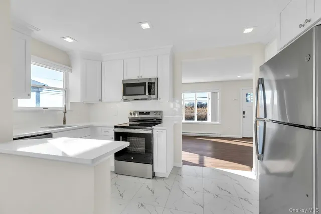 a kitchen with stainless steel appliances a refrigerator sink and stove