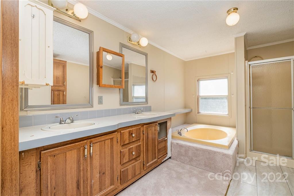 600 East Sandy Ridge Road Monroe, NC 28112 - Photo 21 of 27 a spacious bathroom with a tub sink double vanity and mirror