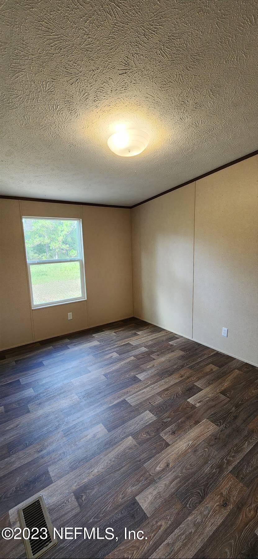 134 Juniper Road Georgetown, FL 32139 - Photo 17 of 20 an empty room with wooden floor and windows