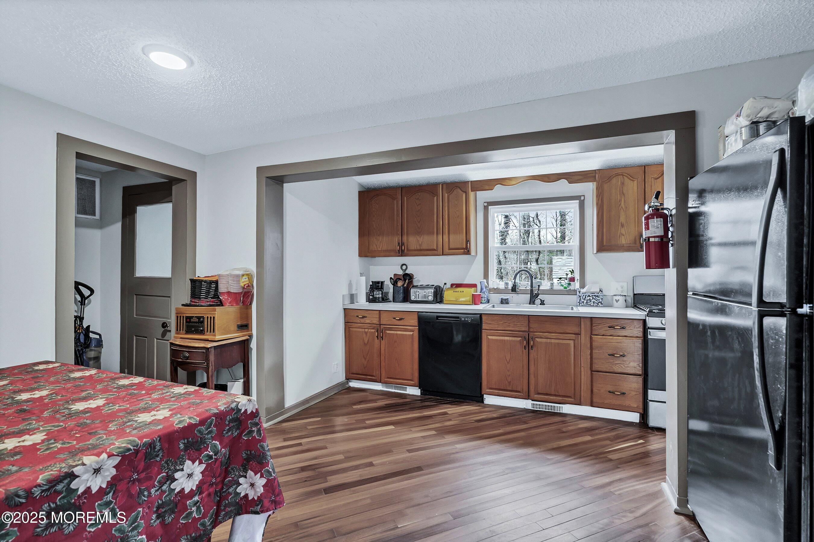 Main Street Barnegat, NJ 08005 - Photo 10 of 26 a kitchen with stainless steel appliances granite countertop a refrigerator a stove and a sink with wooden floor