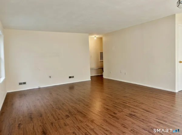 a view of an empty room and wooden floor