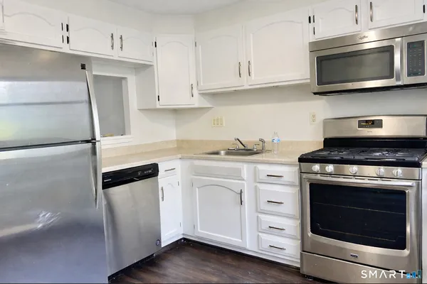 a kitchen with white cabinets and stainless steel appliances